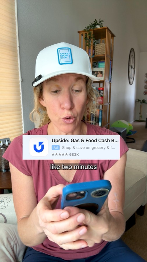 Heather on her phone with the Upside app's App Store listing on screen